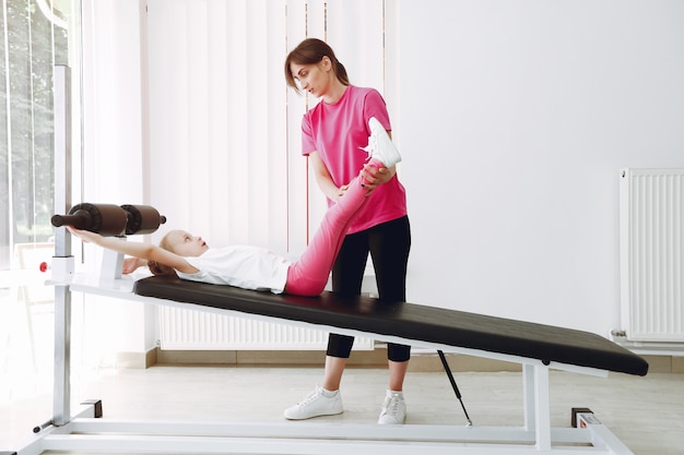 Madre con hija pequeña se dedican a la gimnasia en el gimnasio.