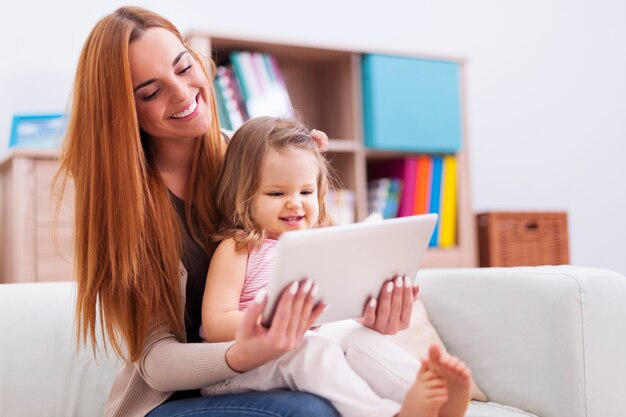 Madre con hija pequeña disfrutando de la red gratuita en casa