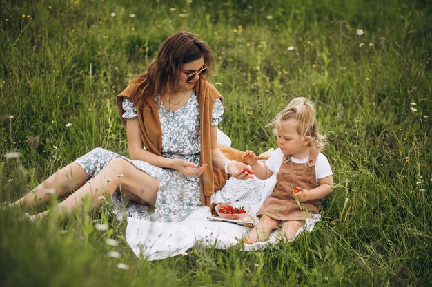 Madre con hija pequeña haciendo picnic en el parque