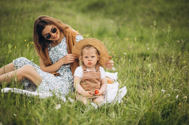 Madre con hija pequeña haciendo picnic en el parque