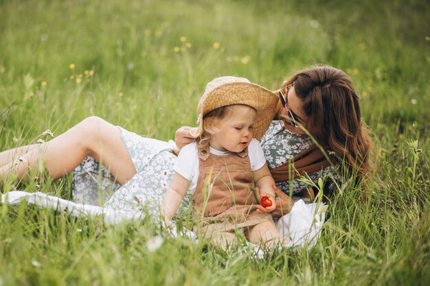 Madre con hija pequeña haciendo picnic en el parque