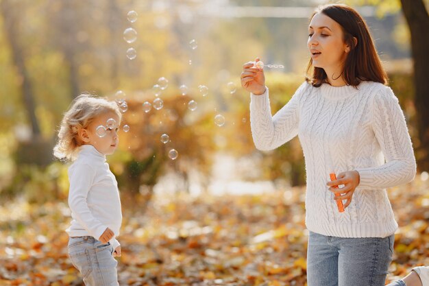 Madre con hija pequeña jugando con burbujas