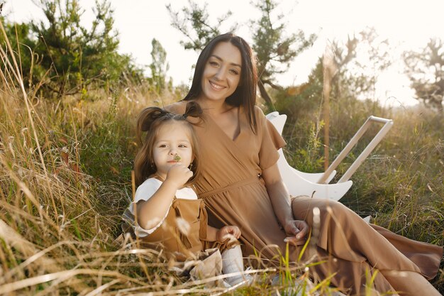 Madre con hija pequeña jugando en un campo de verano