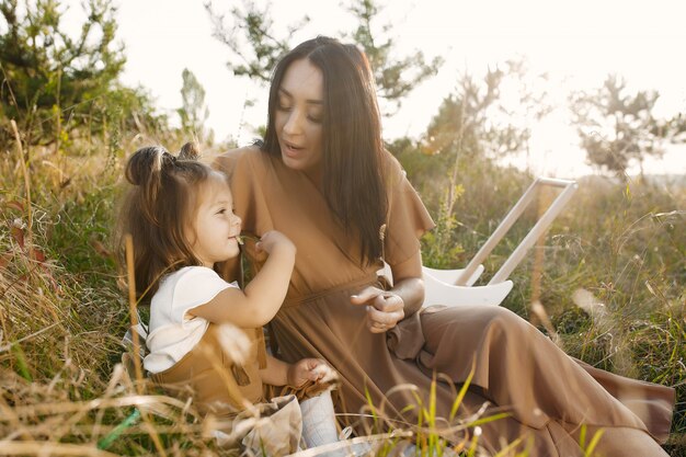 Madre con hija pequeña jugando en un campo de verano