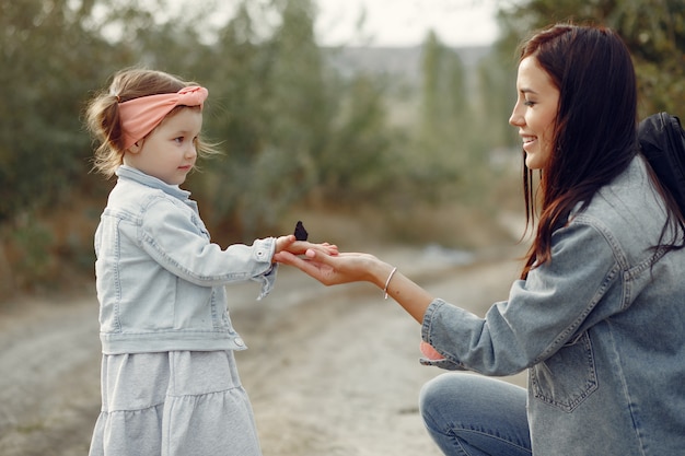 Madre con hija pequeña jugando en un campo