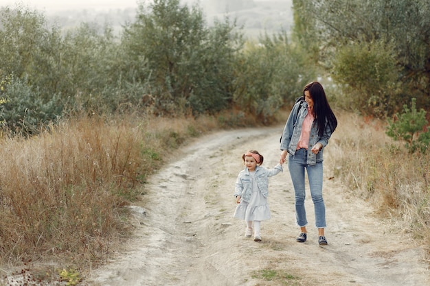 Madre con hija pequeña jugando en un campo