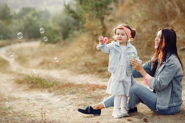 Madre con hija pequeña jugando en un campo