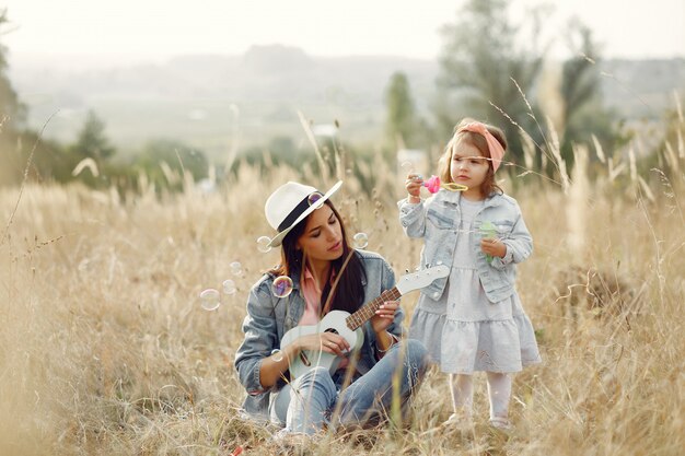 Madre con hija pequeña jugando en un campo