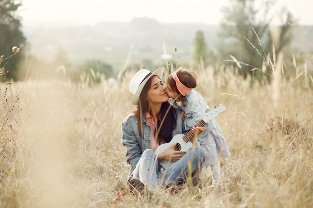 Madre con hija pequeña jugando en un campo