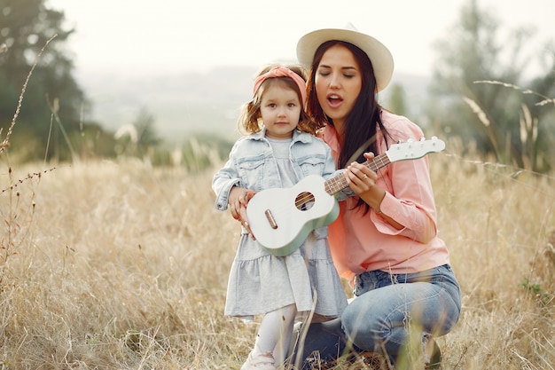 Madre con hija pequeña jugando en un campo