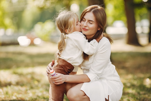 Madre con hija pequeña jugando en un parque de verano