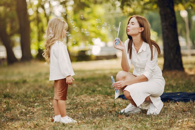 Madre con hija pequeña jugando en un parque de verano