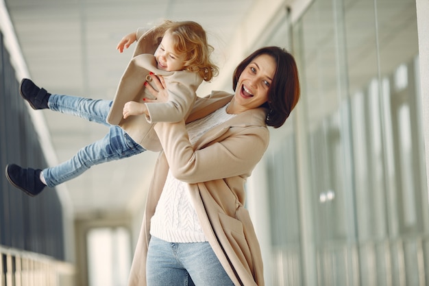 Madre con hija pequeña de pie en un pasillo