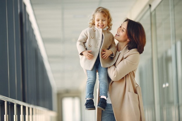 Madre con hija pequeña de pie en un pasillo