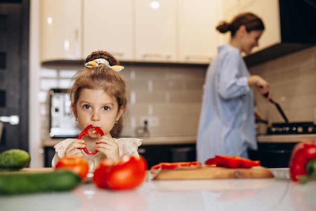 Foto gratuita madre con hija preparando ensalada en la cocina