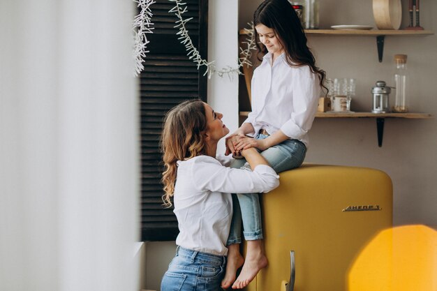 Madre con hija sentada en la cocina