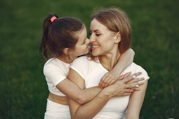 Madre con hija sentada sobre un césped