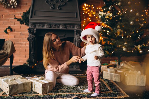 Madre, con, hija, sentado, por, árbol de navidad