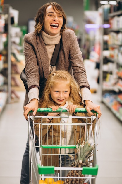 Foto gratuita madre con hija en una tienda de comestibles