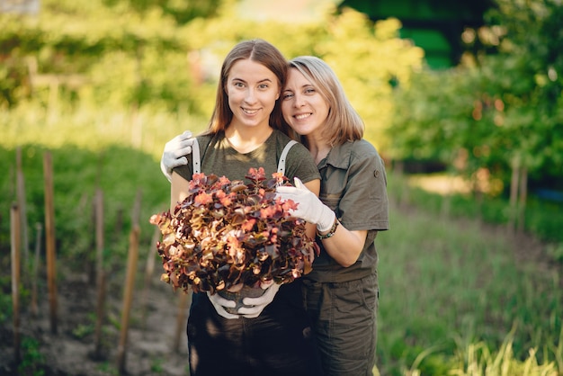 Foto gratuita madre con una hija trabaja en un jardín cerca de la casa