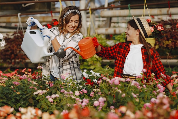 Madre con hija. Trabajadores con maceteros. La gente vierte flores