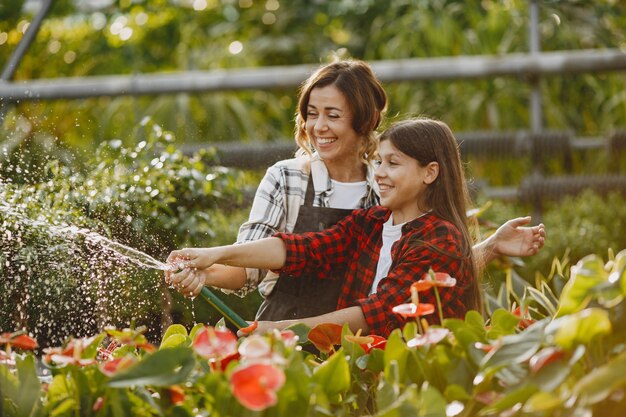 Madre con hija. Trabajadores con maceteros. La gente vierte flores