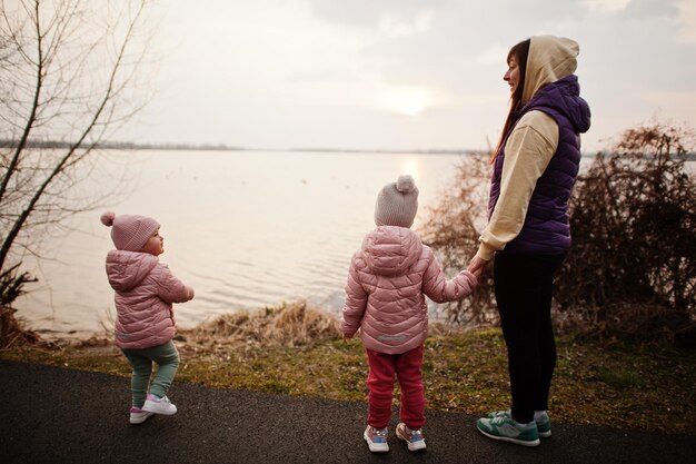 Madre con hijas caminando por el sendero junto al lago