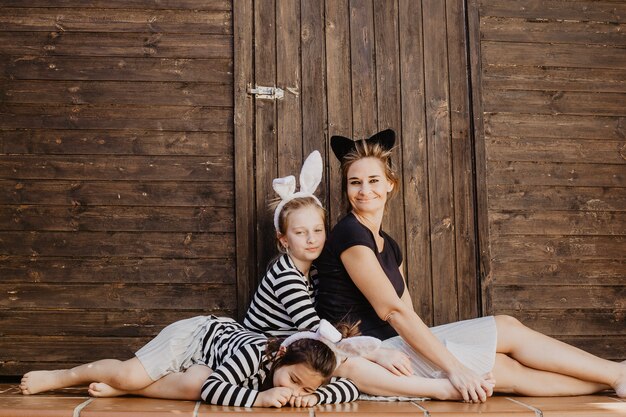 Madre con hijas posando cerca de cobertizo