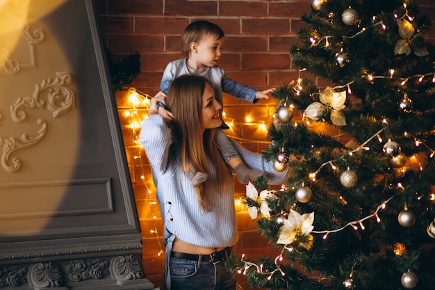 Madre con hijita decorando arbol de navidad