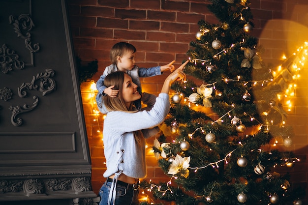 Madre con hijita decorando arbol de navidad