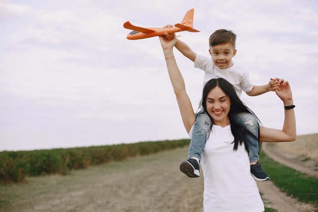 Madre con hijo jugando con avión de juguete