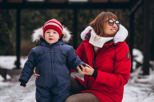 Madre con hijo pequeño afuera en invierno