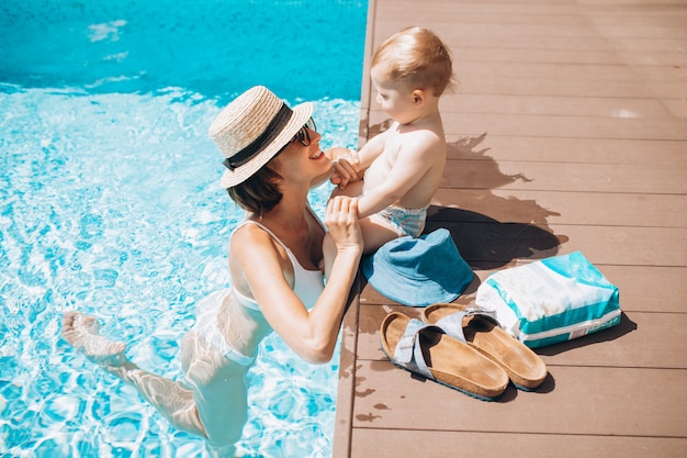 Madre con hijo pequeño divirtiéndose en la piscina