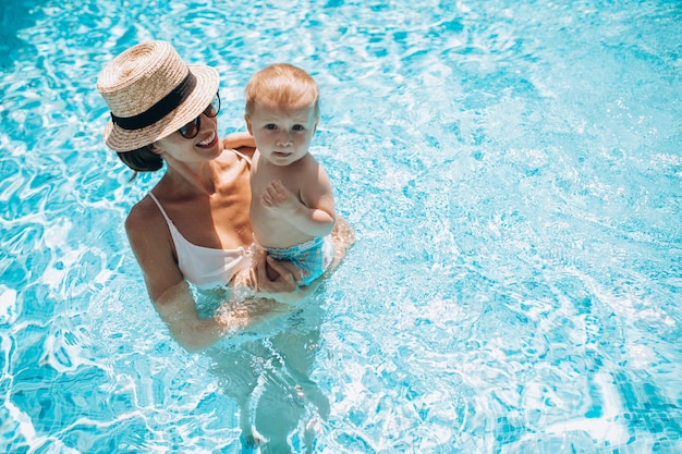 Madre con hijo pequeño divirtiéndose en la piscina