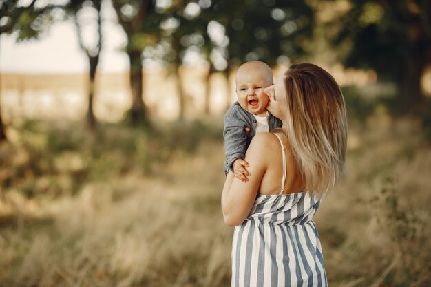 Madre con hijo pequeño jugando en un campo de otoño