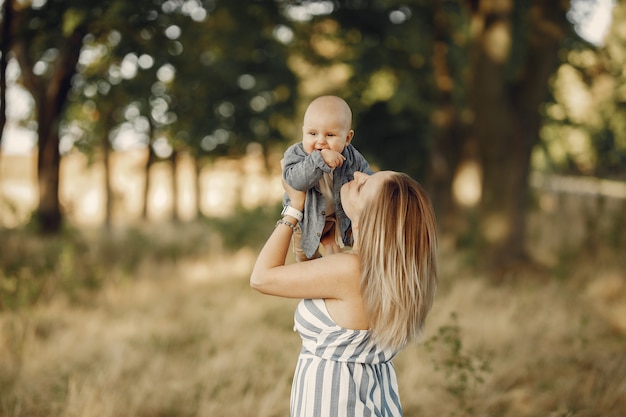 Madre con hijo pequeño jugando en un campo de otoño