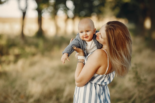 Madre con hijo pequeño jugando en un campo de otoño