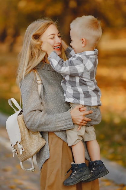 Madre con hijo pequeño jugando en un campo de otoño