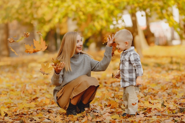 Madre con hijo pequeño jugando en un campo de otoño