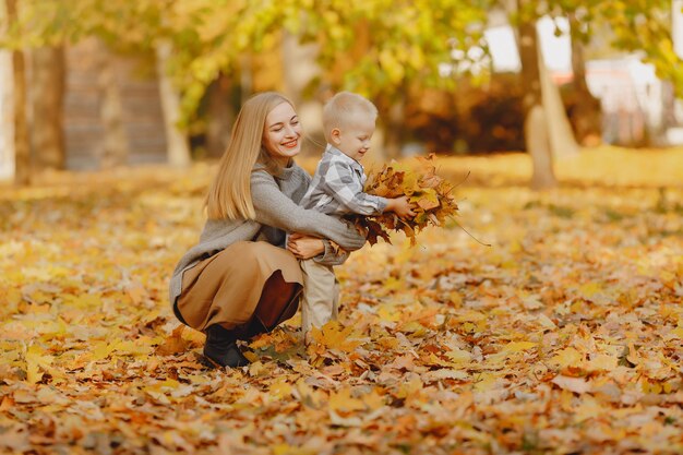 Madre con hijo pequeño jugando en un campo de otoño