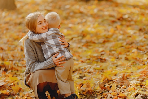 Madre con hijo pequeño jugando en un campo de otoño