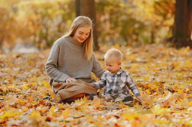 Madre con hijo pequeño jugando en un campo de otoño