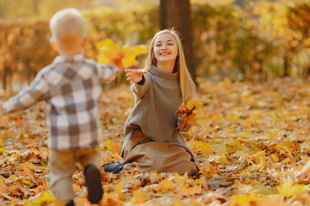 Madre con hijo pequeño jugando en un campo de otoño