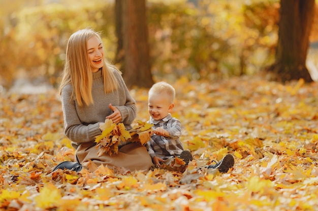 Madre con hijo pequeño jugando en un campo de otoño