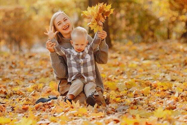 Madre con hijo pequeño jugando en un campo de otoño