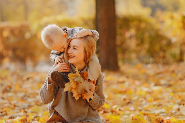 Madre con hijo pequeño jugando en un campo de otoño