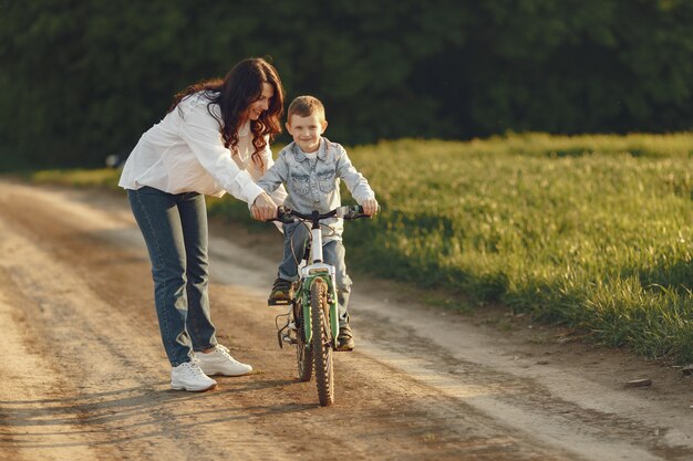 Madre con hijo pequeño jugando en un campo de otoño