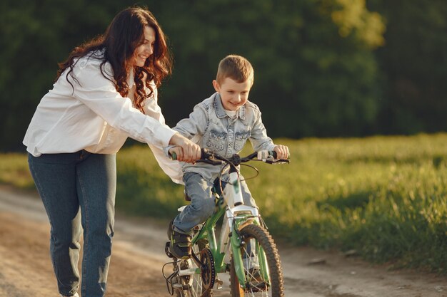 Madre con hijo pequeño jugando en un campo de otoño