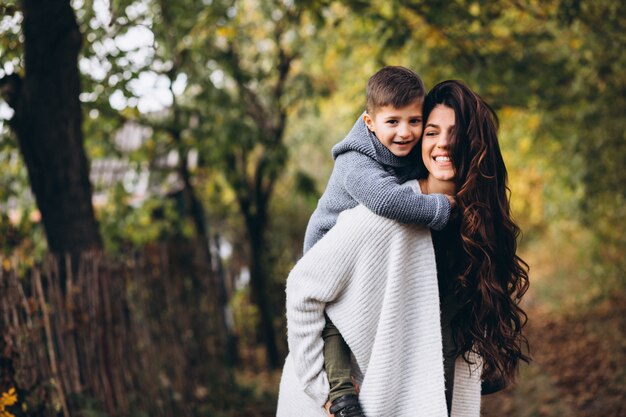 Madre con hijo pequeño en un parque de otoño