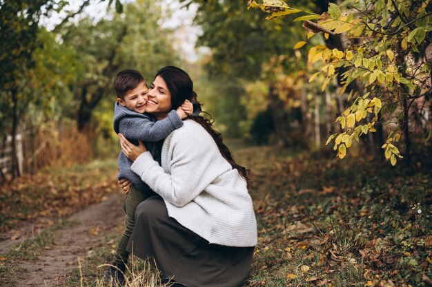 Madre con hijo pequeño en un parque de otoño